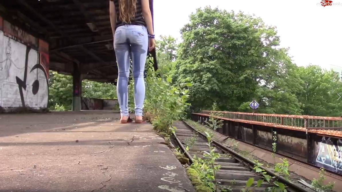 Click to play video Girl wetting her jeans at an abandoned train station